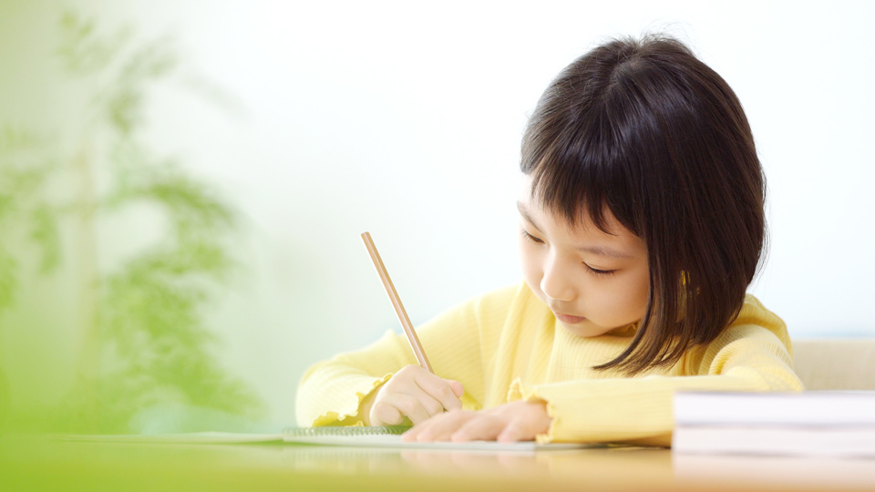 ノートにまとめを書く子ども